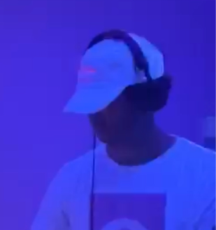 In the booth under blue light, headphones on